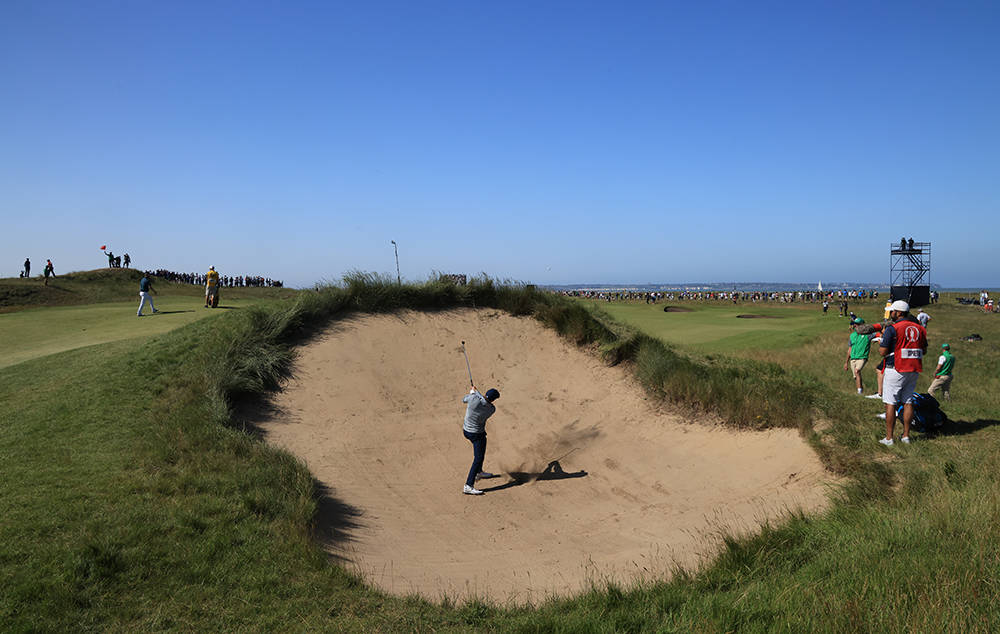 Jordan Spieth playing from a deep bunker